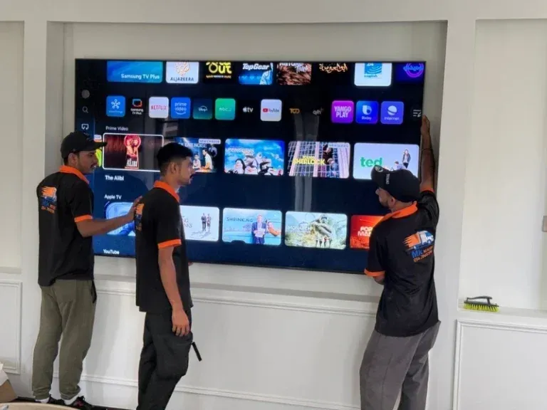 MK Movers team installing and mounting a large Samsung smart TV during home relocation