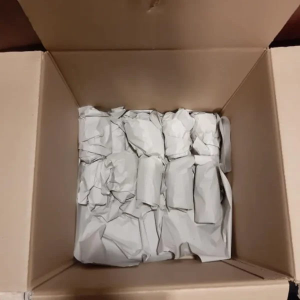 Fragile items wrapped in paper packed inside cardboard box for moving