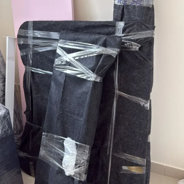 Furniture wrapped in protective blanket and tape ready for safe moving
