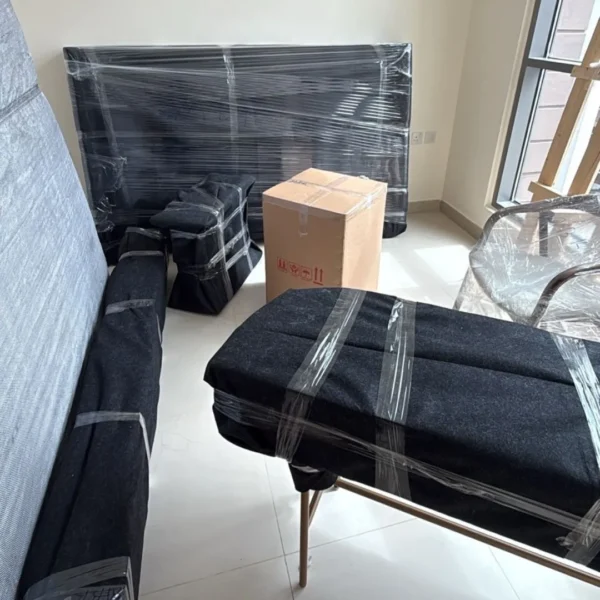 Room full of wrapped furniture and packed boxes ready for moving Dubai